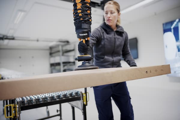 Vacuum lifting equipment guide - TAWI high frequency lifter handling a box in a warehouse